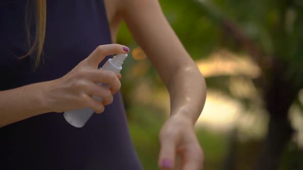 Superslowmotion Shot of a Beautiful Young Woman Applying an Antimosquito Repellent Spray on Her Skin