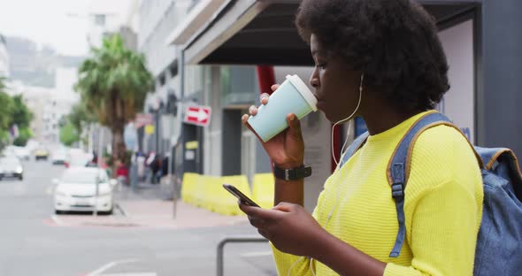 African american using her smartphone in street