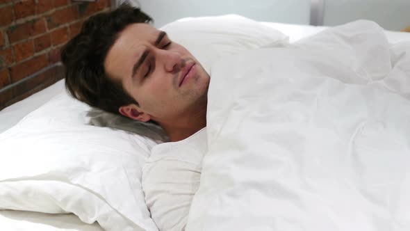 Uncomfortable Man Sleeping in Bed at Night, Restlessness