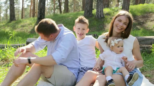 Happy Family of Four on Picnic at Summer Sunny Day