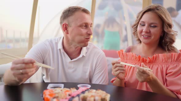 a Man Jokes and Feeds a Woman Rolls