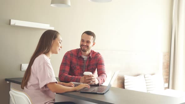 Handsome Man Together with Beautiful Young Woman Spending Time in Front of Laptop Computer