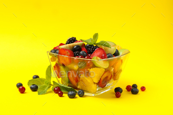 Bowl of fresh fruit salad on yellow background, space for text / Photodune, Misc