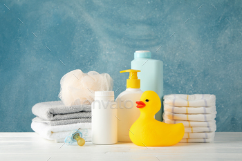 Baby hygiene accessories on wooden table against blue background / Photodune, Misc