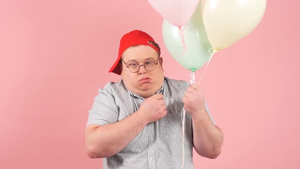 Happy Man Dressed in Childish Style Laughing Joyfully While Holding Air Balloons, Slow Motion