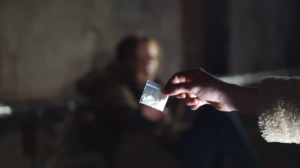 Human Hand Holding Bag with Cocaine and Man on Background Refusing To Take It