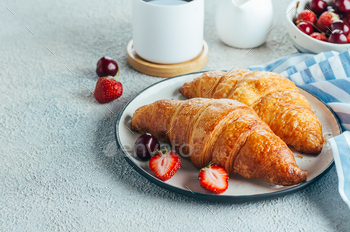 Delicious breakfast food concept. Coffee, croissants and berries for breakfast on light background. / Photodune, Misc