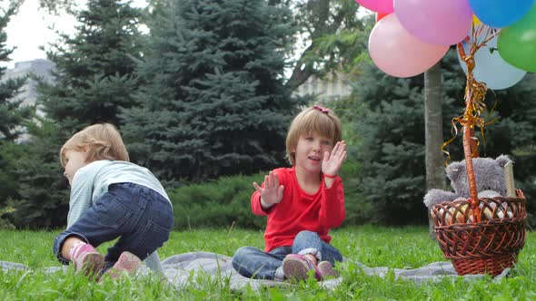 Two Little Girls with Balloons in the Park