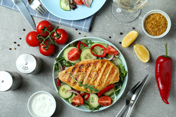 Concept of tasty eating with salad with grilled chicken on gray textured table / Photodune, Misc