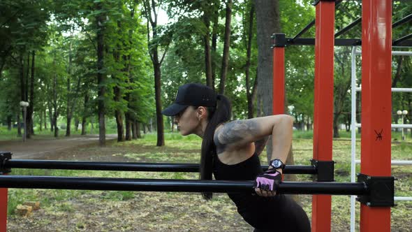 Sporty Woman Dips on the Uneven Bars in the Park at Sunset Sport and Healthy Lifestyle