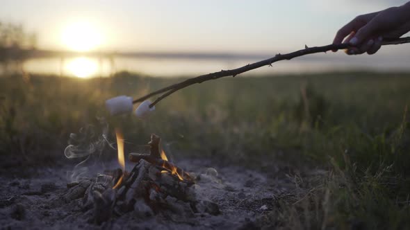 Roasting Marshmallows Over Bonfire on the Beach at Sunset