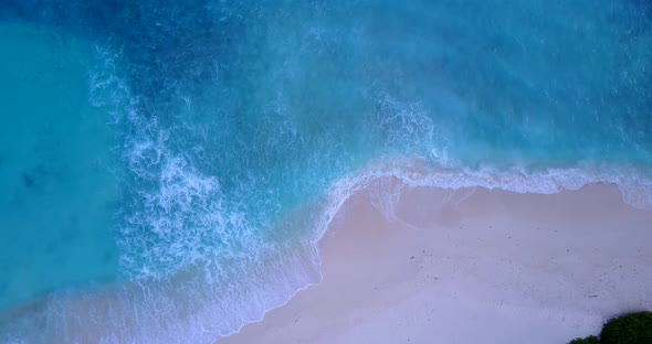 Daytime birds eye travel shot of a white paradise beach and blue ocean background in 4K