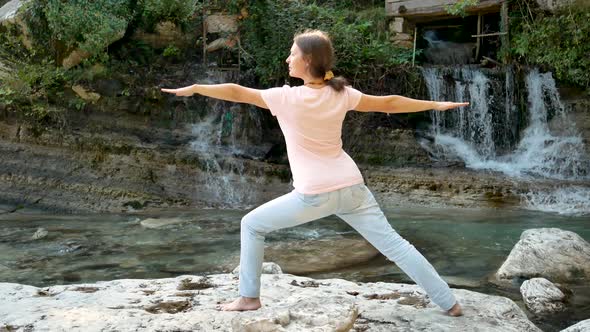 Young woman is practicing yoga in Warrior Pose 