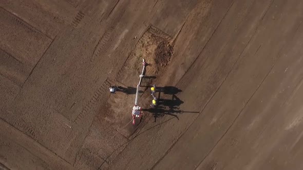 Workers Are Inspecting and Servicing Small Oil Well in Field, , in Summer Day, Aerial View