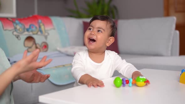 Happy baby playing with his mother.