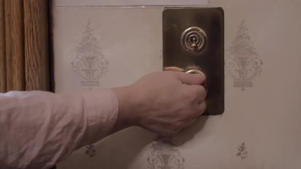 Hand turning off old vintage brass style lights