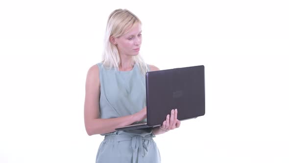 Happy Young Beautiful Blonde Woman Thinking While Using Laptop