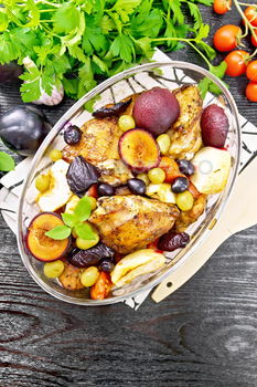 Chicken with fruits and tomatoes in glass pan on dark board top / Photodune, Misc