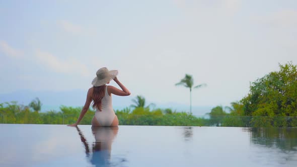 Young asian woman enjoy around outdoor swimming pool for leisure