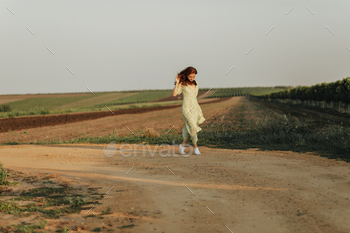 Full length photo of young woman with ginger wavy hair in long stylish green and yellow dress and l / Photodune, Misc