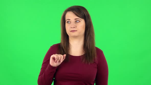 Portrait of Pretty Girl Talking About Something Pointing at Him, Copy Space. Green Screen