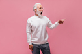 Shocked man in white sweater pointing to place for text. Surprised adult guy in eyeglasses and mode - PhotoDune Item for Sale
