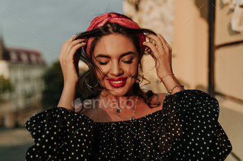 Smiling fashionable young woman with curly dark hair, bright bandana and red lipstick in wide long / Photodune, Misc