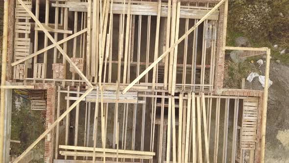 Top down aerial view of a house under construction with wooden roof frame.