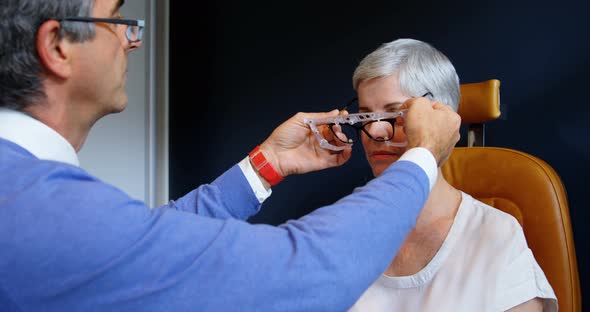 Optometrist examining patient eyes with eye test equipment 4k