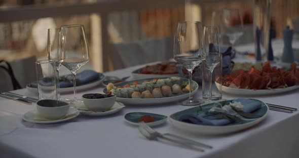 Long festive table with snacks and flowers in nature