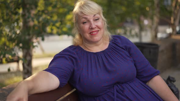 Happy Fat Woman Sitting on a Bench