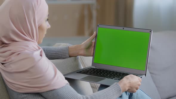 Serious Muslim Girl in Hijab Woman Freelancer Developer Sitting on Couch Home Office Using Laptop