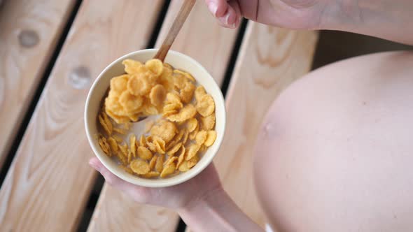 Top View Of Pregnant Woman Eating Cereals For Breakfast.