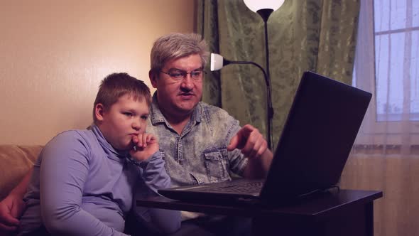 The Boy and His Dad Study Online at Home Watching and Listening to the Lesson