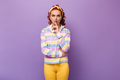 Blue-eyed woman in yellow pants and multi-colored sweatshirt puts her finger to her mouth asking to - PhotoDune Item for Sale