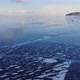 Aerial View of a Group of Travelers Skating on the Ice of a Frozen Lake - VideoHive Item for Sale