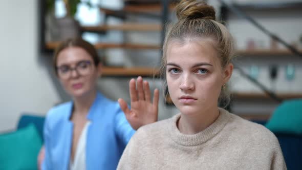 Portrait of Beautiful Teenage Girl Looking at Camera Smiling As Blurred Psychologist Touching