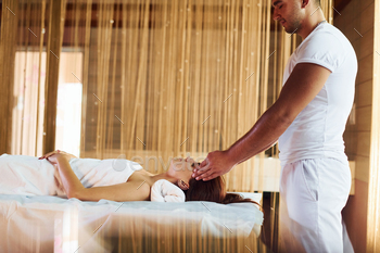 Man does massage to the young woman in white towel indoors / Photodune, Misc