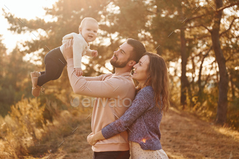 Happy family of mother, family and little baby rests outdoors. Beautiful sunny autumn nature / Photodune, Misc