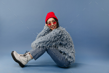 Stylish asian girl with modern bright sunglasses and red cap in blue fashionable warm outfit and wh / Photodune, Misc