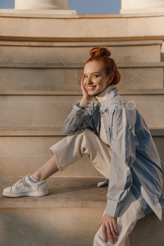 Beauty portrait of trendy young lady posing on stairs outdoors. Attractive red-haired girl in light / Photodune, Misc
