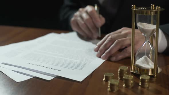 Serious Businessman Signing Purchase Agreement as Time Flows With Sand in Clock