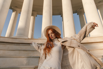 Beauty portrait of young girl against sunlit columns background. Stylish foxy lady wearing light to / Photodune, Misc