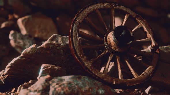 Old Wooden Wheel on Rocks alt