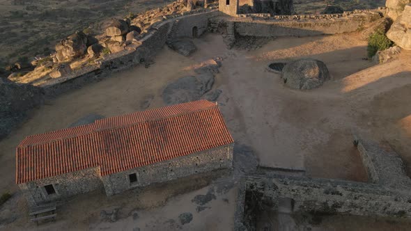 Aerial orbit around old building at Monsanto ruins during sunrise, Portugal