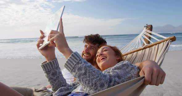 Couple using digital tablet at beach 4k