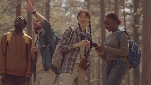 Multiethnic Friends Chatting on Walk in Forest