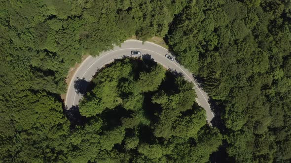 Oncoming traffic at a tight curve, topdown droneshot from above, high resolution, steady shot from b