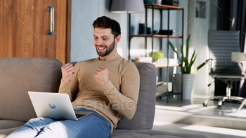 oung man working on a laptop on the couch