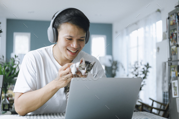 Asian businessman talking to colleague team in video call conference with kitten and smile face. / Photodune, Misc